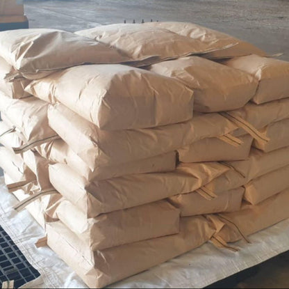 Stack of brown paper bags on a pallet in an industrial setting