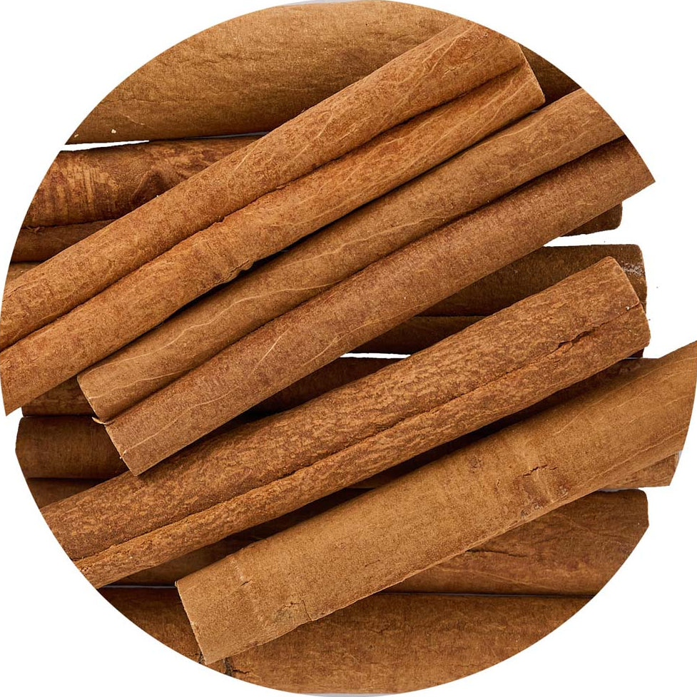 A close-up circular arrangement of cinnamon sticks with warm brown tones on a white background.
